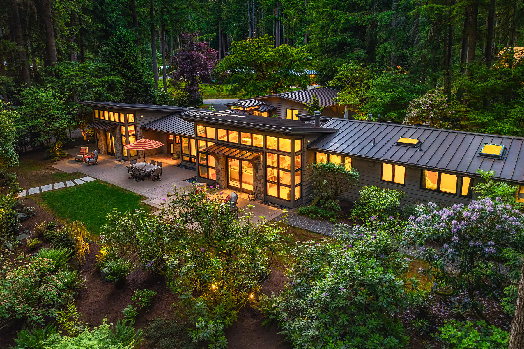 Aerial view of 18 Bridlewood Circle at twilight, set in the cedars of Bridle Trails